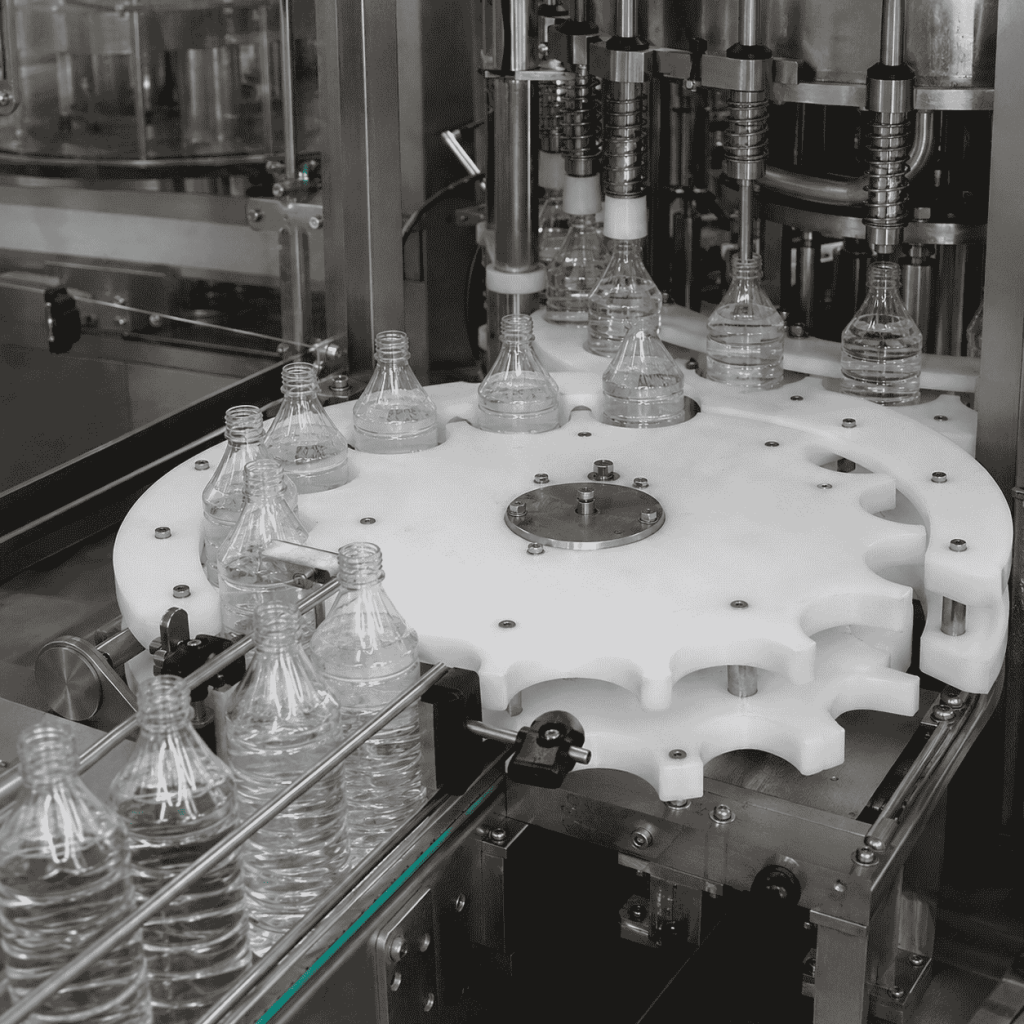 UHMWPE infeed star wheel guiding PET bottles on a filling line